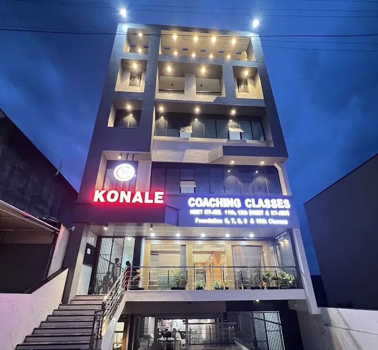 The lit front of the Konale Coaching Classes building in Udgir at dusk